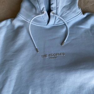 The is a never before worn, light blue hoodie by the Kooples.